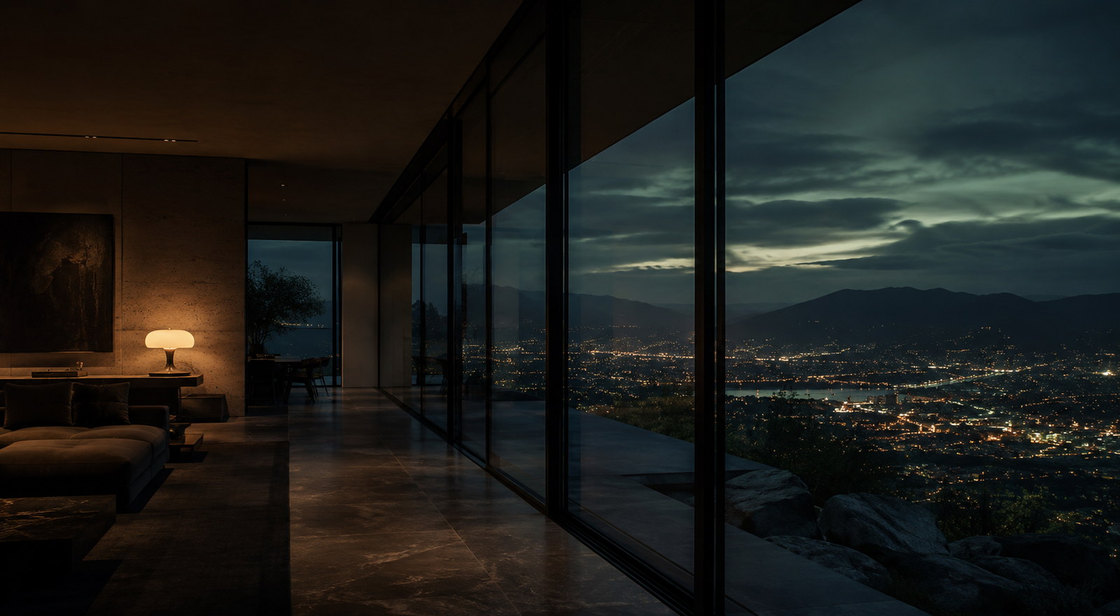 Living room with floor-to-ceiling glass overlooking the Medell&iacute;n valley at night